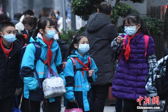 学生们戴着口罩有序进入校园