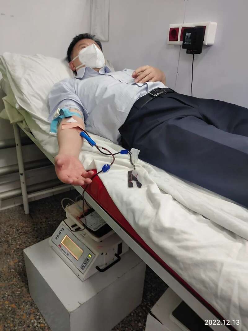 大使戴着口罩，躺在床上献血
