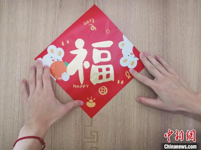 图为济南市民在家中张贴兔年福字