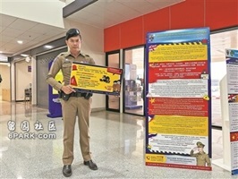 一名泰国警察举着警示牌提醒民众谨防电信诈骗 一名泰国警察举着警示牌提醒民众谨防电信诈骗